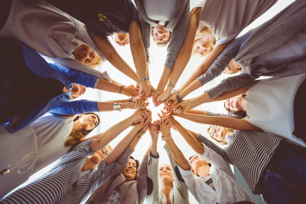 Women’s team. Large group of woman holding hands. Low angle view.